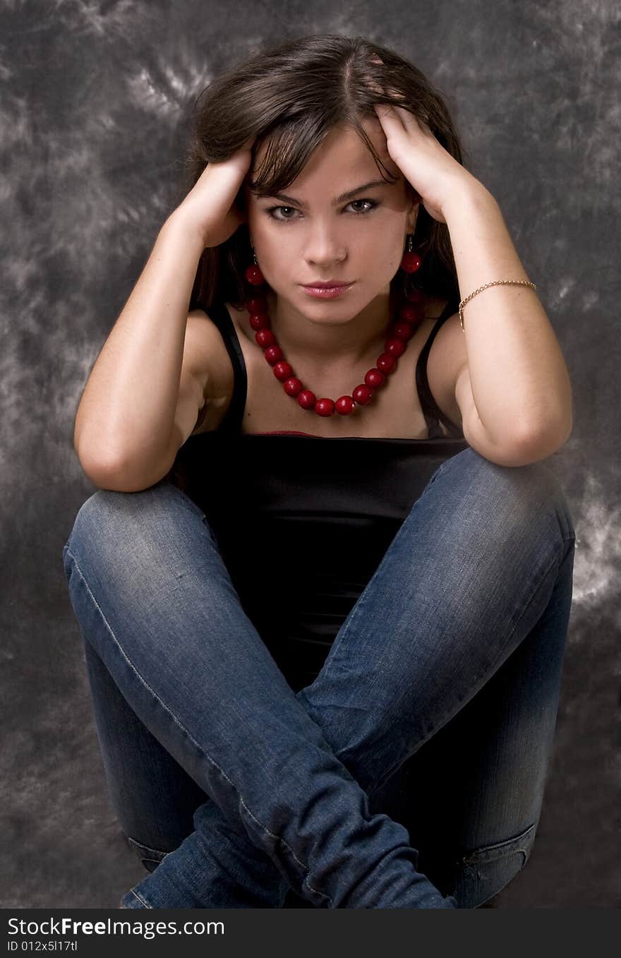 A beautiful young girl sits crossing feet. A beautiful young girl sits crossing feet