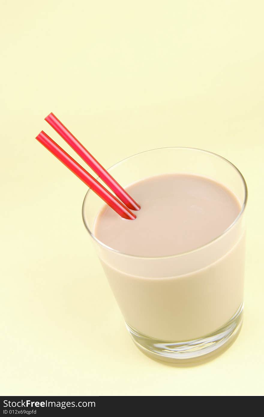 A glass of chocolate milk isolated against a yellow background