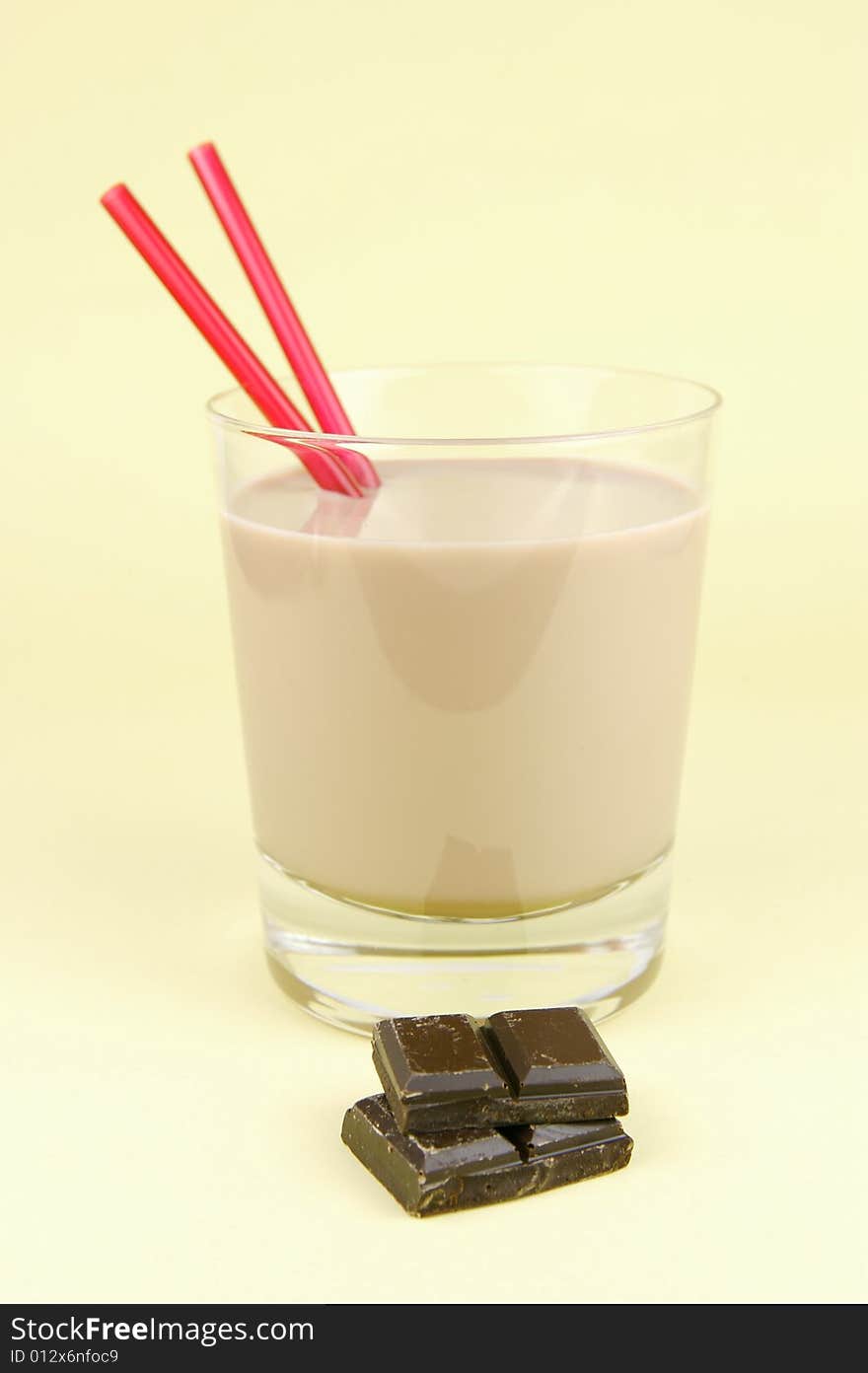 A glass of chocolate milk isolated against a yellow background