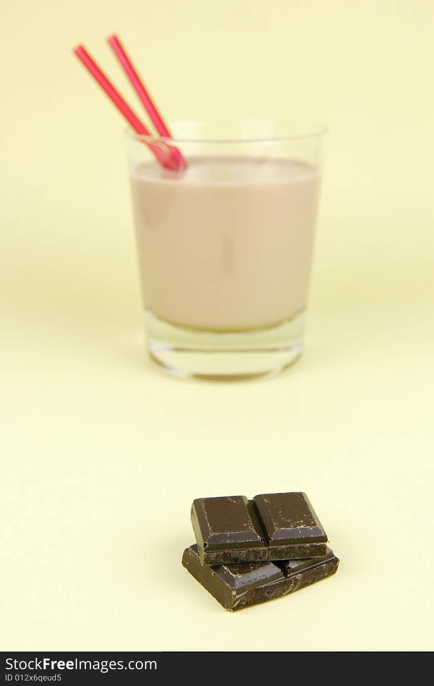 A glass of chocolate milk isolated against a yellow background