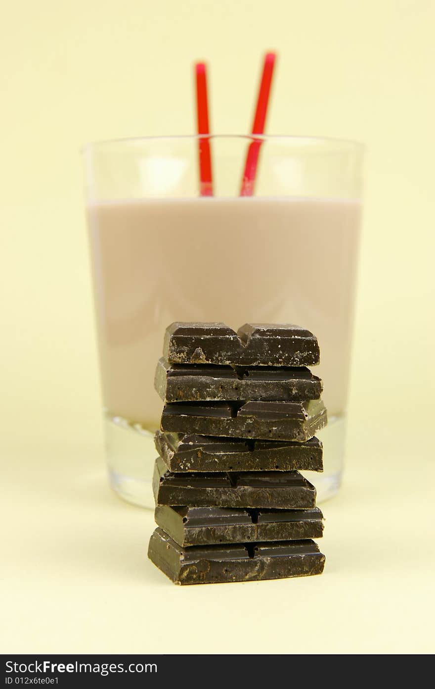 A glass of chocolate milk isolated against a yellow background