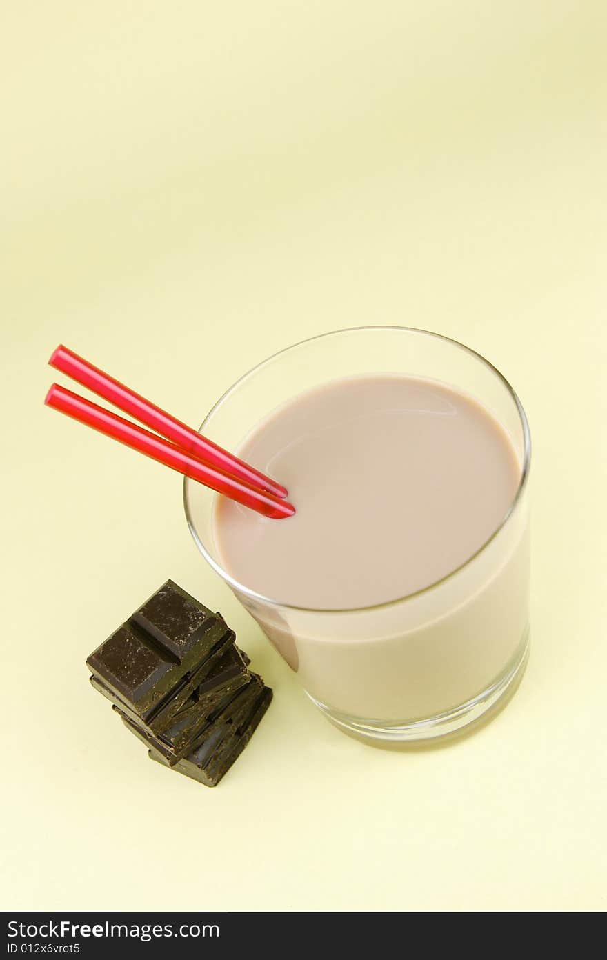 A glass of chocolate milk isolated against a yellow background