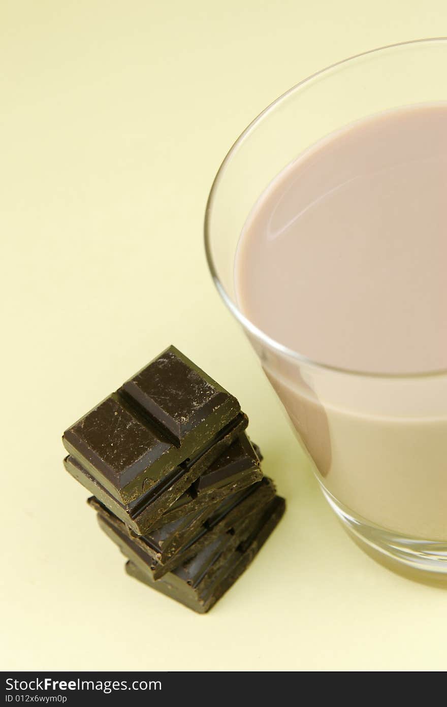 A glass of chocolate milk isolated against a yellow background