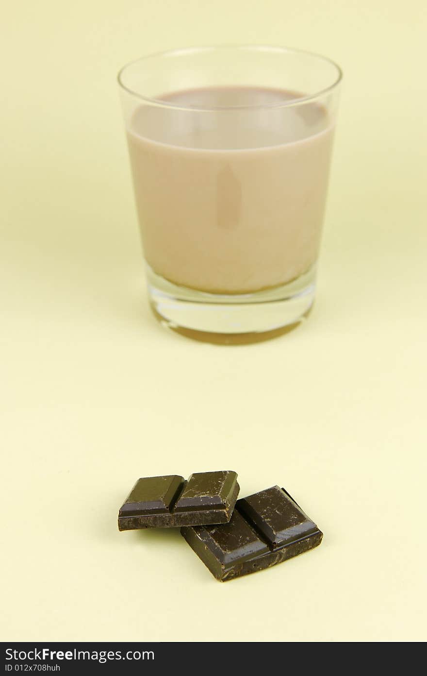 A glass of chocolate milk isolated against a yellow background