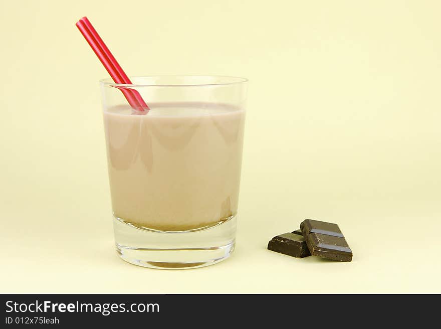 A glass of chocolate milk isolated against a yellow background