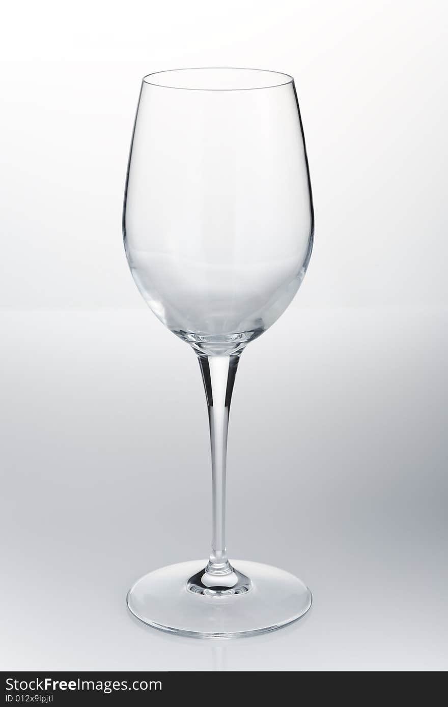 Empty red wine glass on the white reflective table