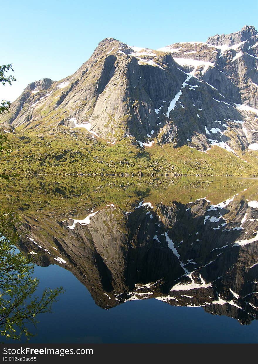 The mountains mirroring in the Storvatten lake, Lofoten islands. The mountains mirroring in the Storvatten lake, Lofoten islands