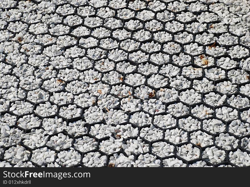 Small roses from white stones are laid out on a floor. Small roses from white stones are laid out on a floor.