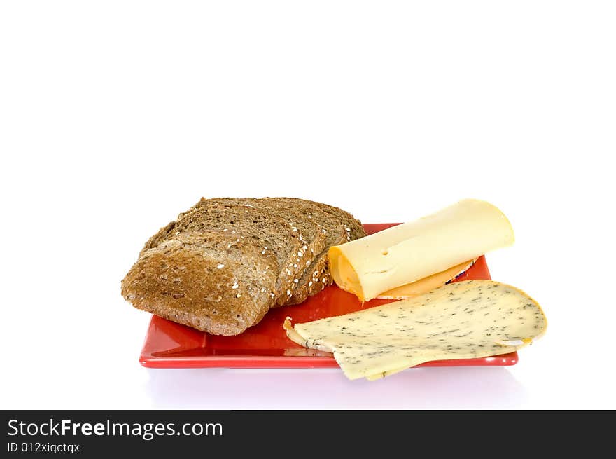 Bread and cheese on red platter, white background, reflective surface