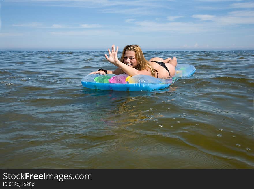 Beautiful girl swimming on mattress