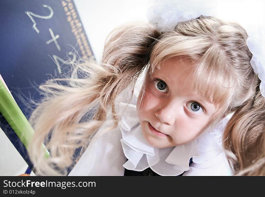 An image of Little girl standing near chalkboard. An image of Little girl standing near chalkboard.