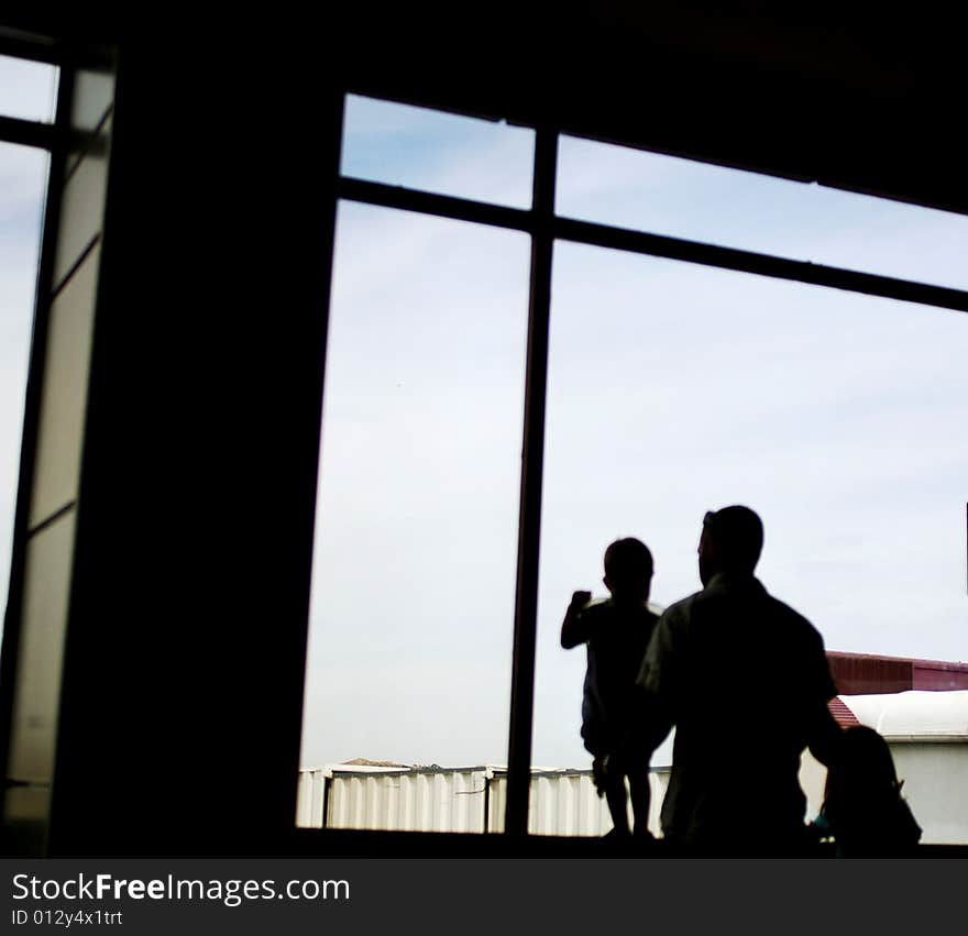 Silhouette of a father with son and daughter at the window. Silhouette of a father with son and daughter at the window