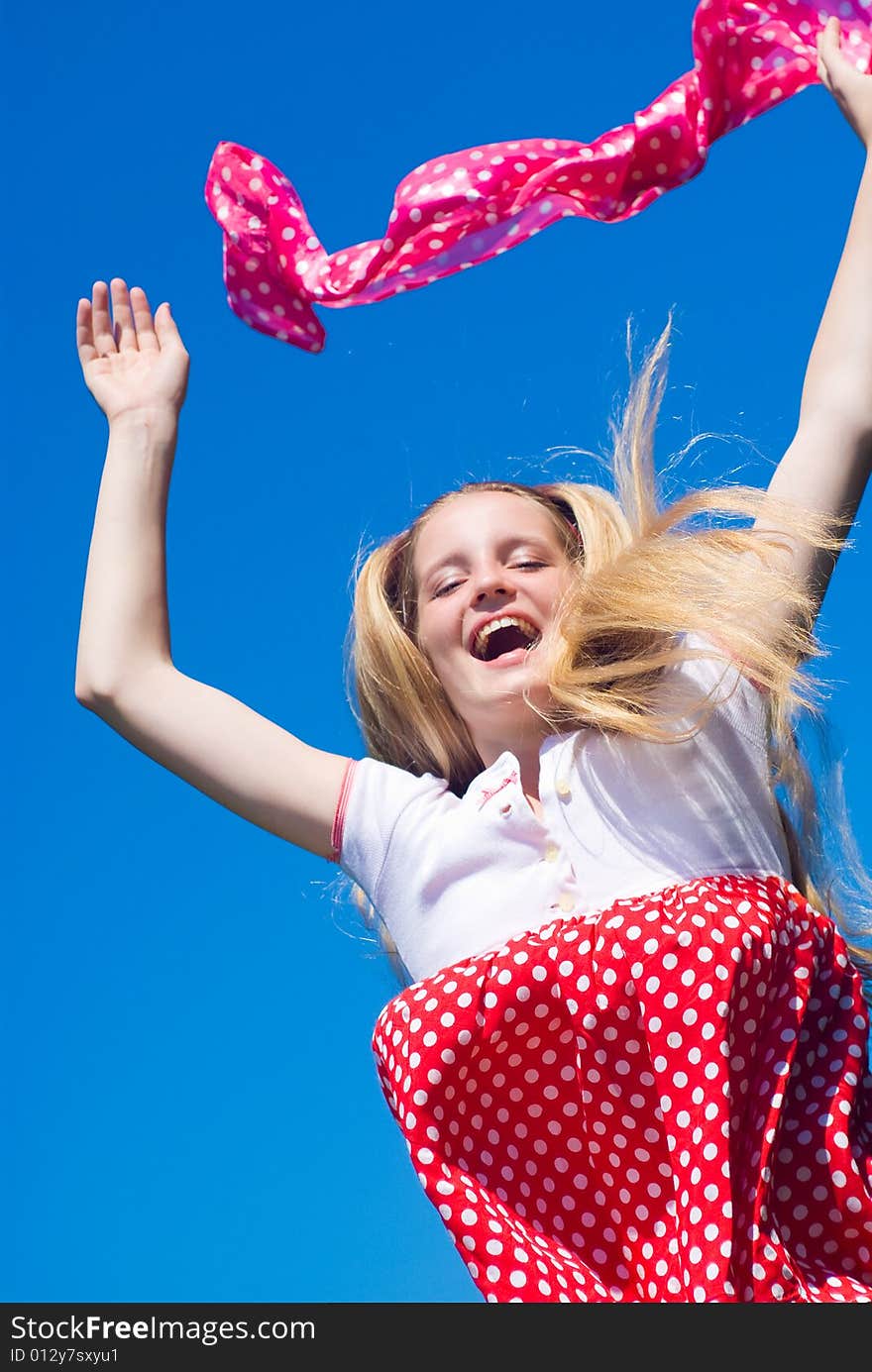 Happy jumping girl on blue sky background