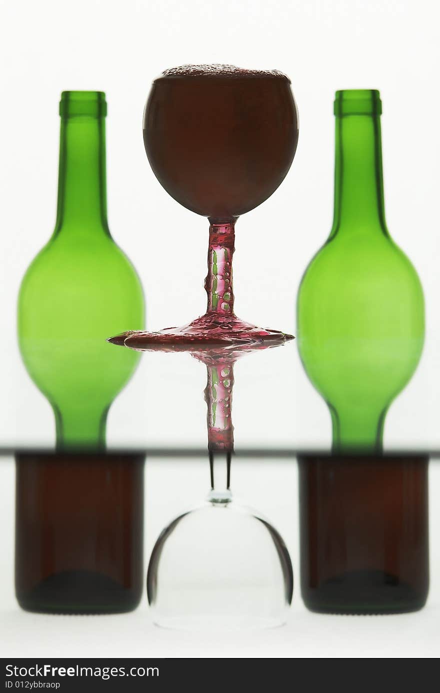 Wine in a glass overflowing against semi abstract background. Wine in a glass overflowing against semi abstract background