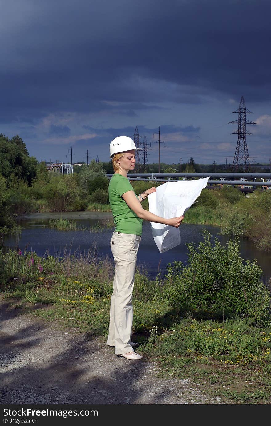 Woman engineer with white safety hat drawings