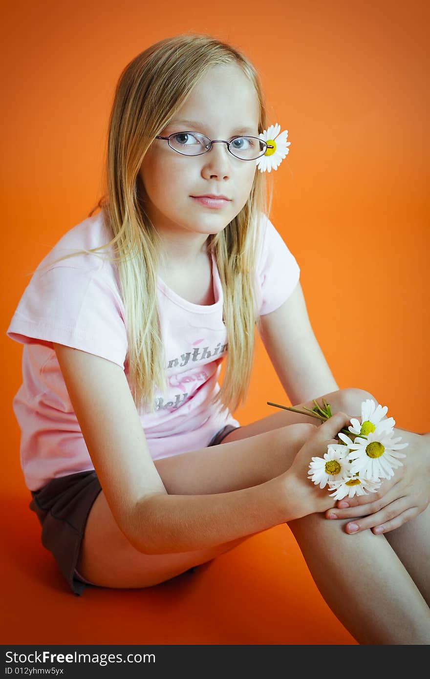 Young girl sitten on the  orange background. Young girl sitten on the  orange background