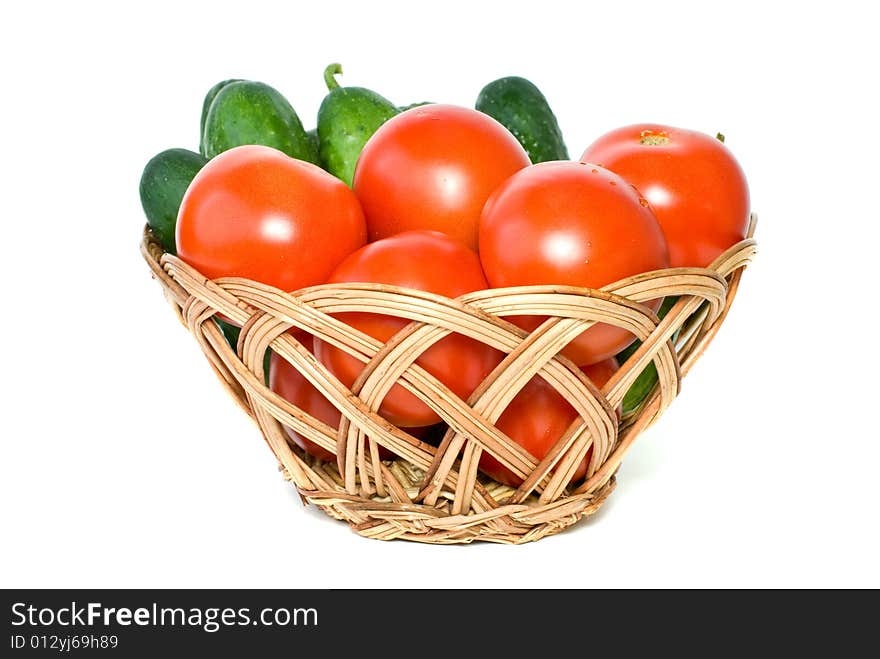 Basket with tomatoes and cucumbers isolated on the white background