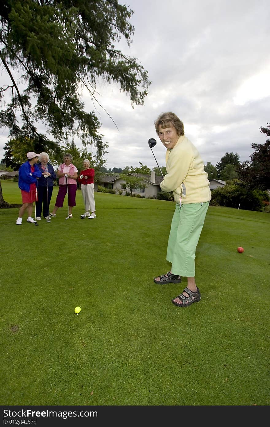 Five elderly women playing golf