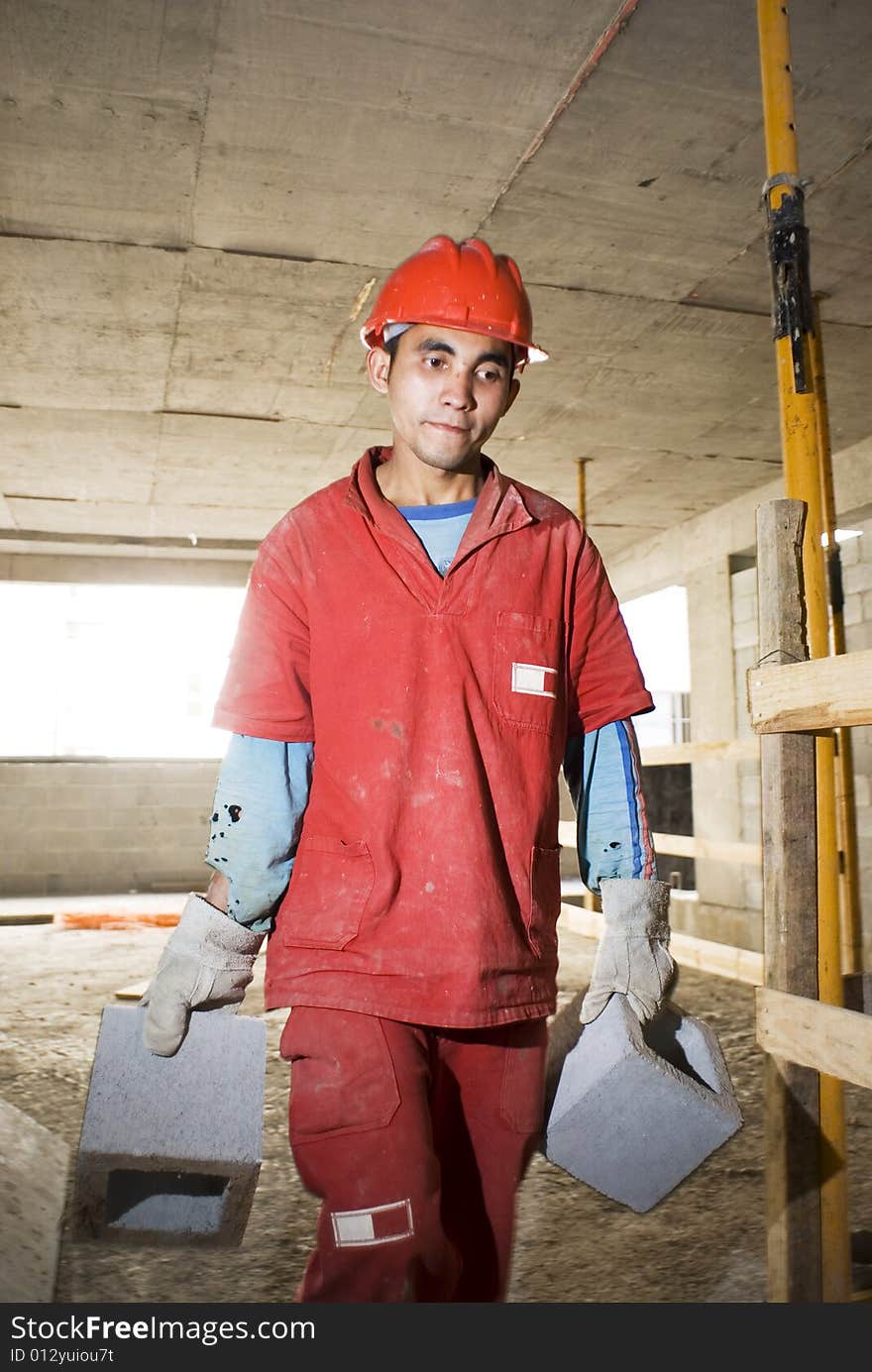 Worker Carries Cinder Blocks