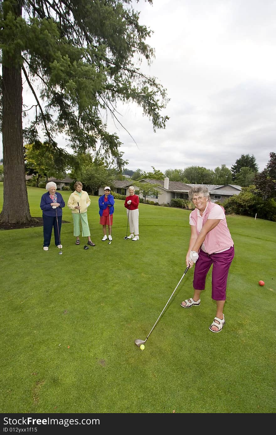 Five happy elderly women playing golf. Vertically framed photo.