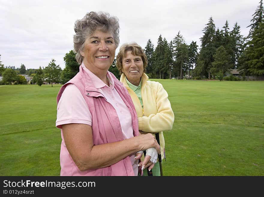 Two elderly female golfers smiling. Horizontally framed photo. Two elderly female golfers smiling. Horizontally framed photo.