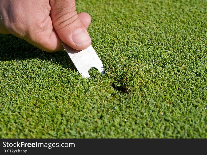 Man s Hand Repairs Divot