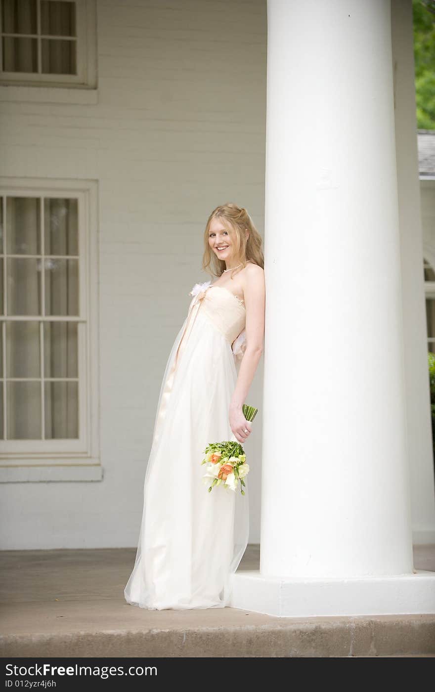 Bride leaning on a large column