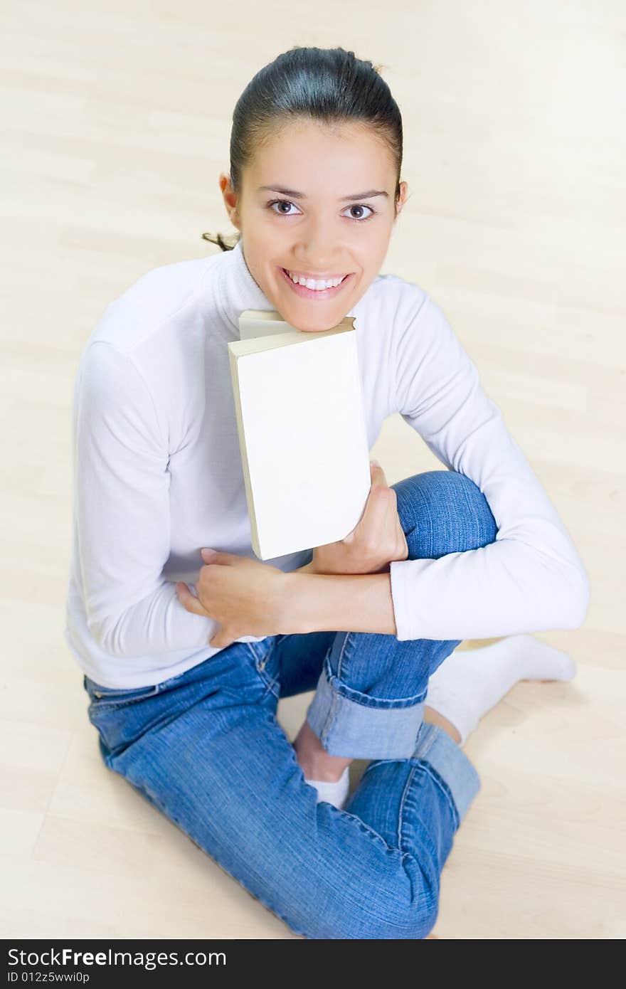 Young woman sitting at home and reading book