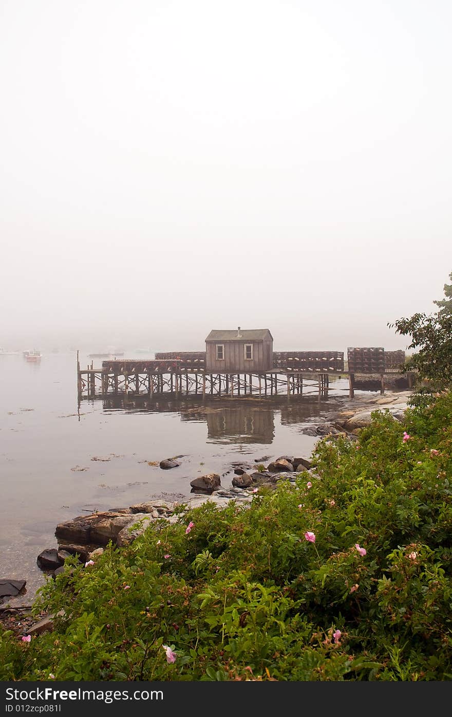 A view of a fishing wharf and shack on Bass Harbor in dense, coastal Maine fog. A view of a fishing wharf and shack on Bass Harbor in dense, coastal Maine fog.