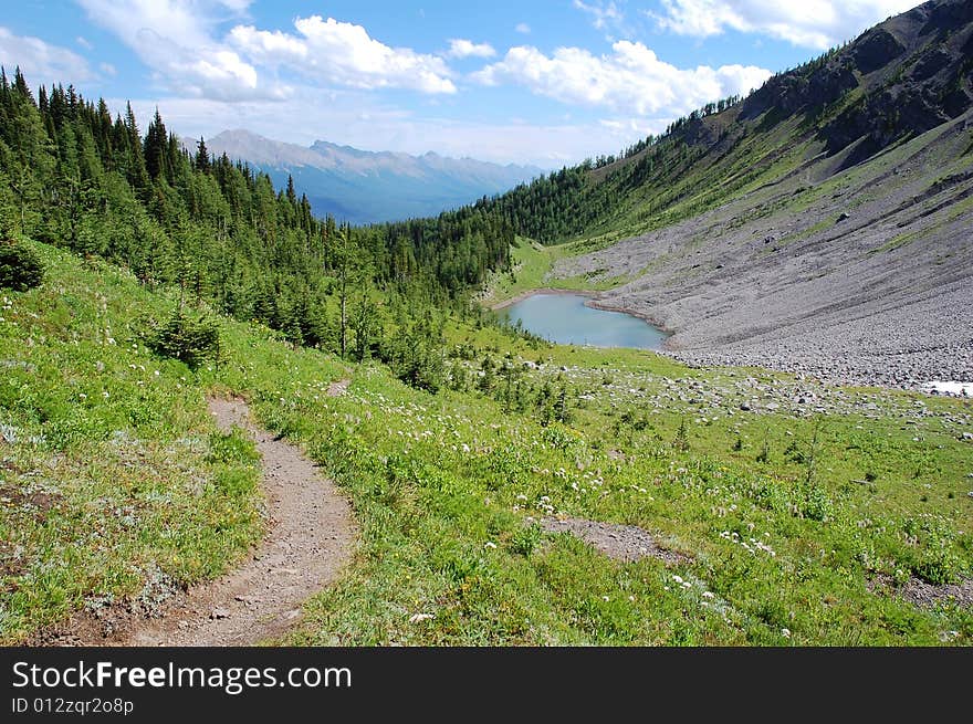 Alpine lake and meadows on mountains indefatigable, kananaskis country, alberta, canada