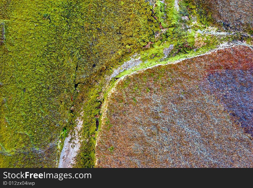 Colored (prevaling green and brown) rough stone surface with lichen