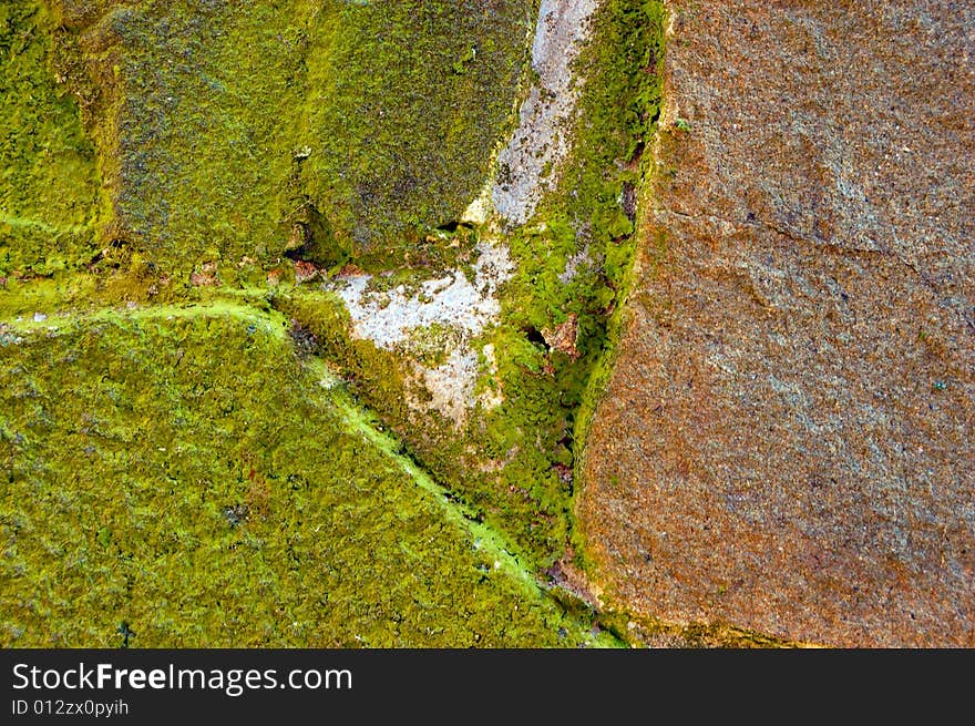 Colored (prevaling green and brown) rough stone surface with lichen