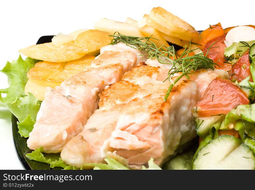 Stake from a salmon with vegetables on a plate. Closeup.