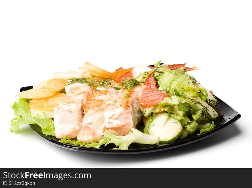 Stake from a salmon with vegetables on a plate. Closeup.