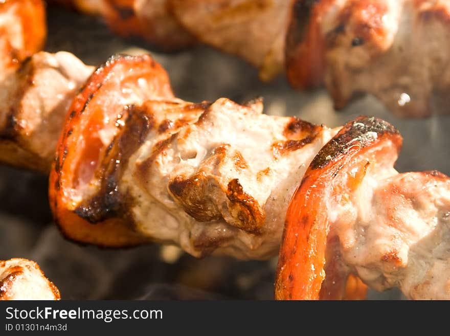 Shish kebab preparation on a brazier. Outdoor picnic. Close up.