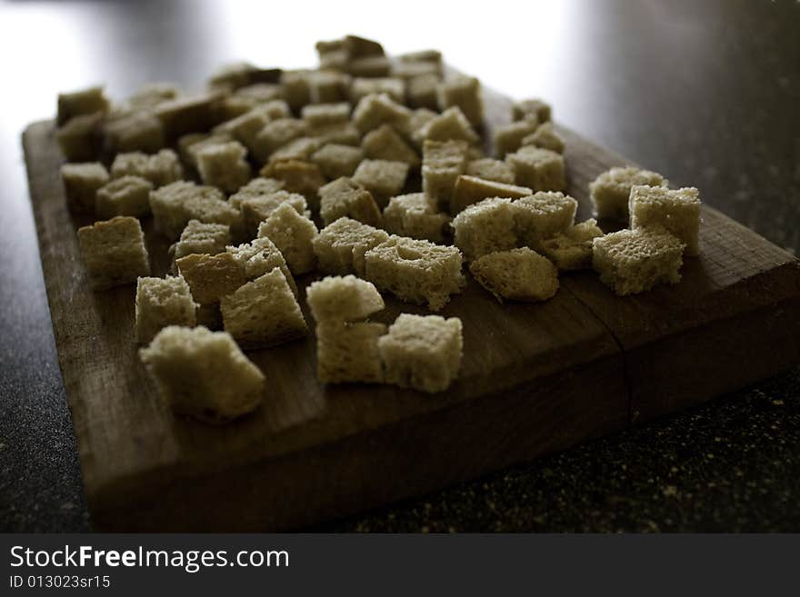 Dried pieces of bread on a wooden knife board. Dried pieces of bread on a wooden knife board