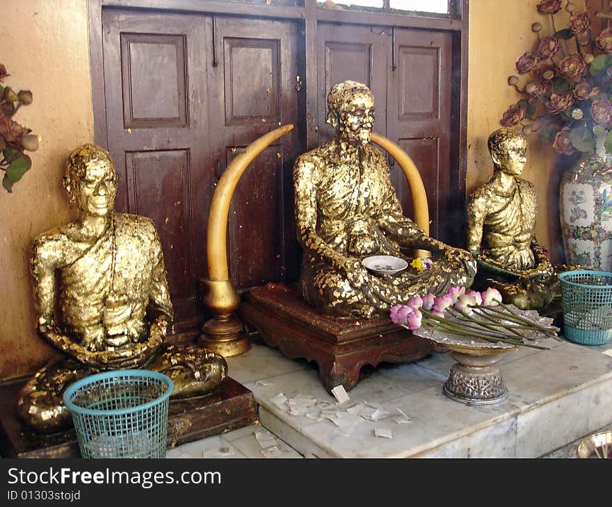 Gilded statues of monks in a shrine in Thailand