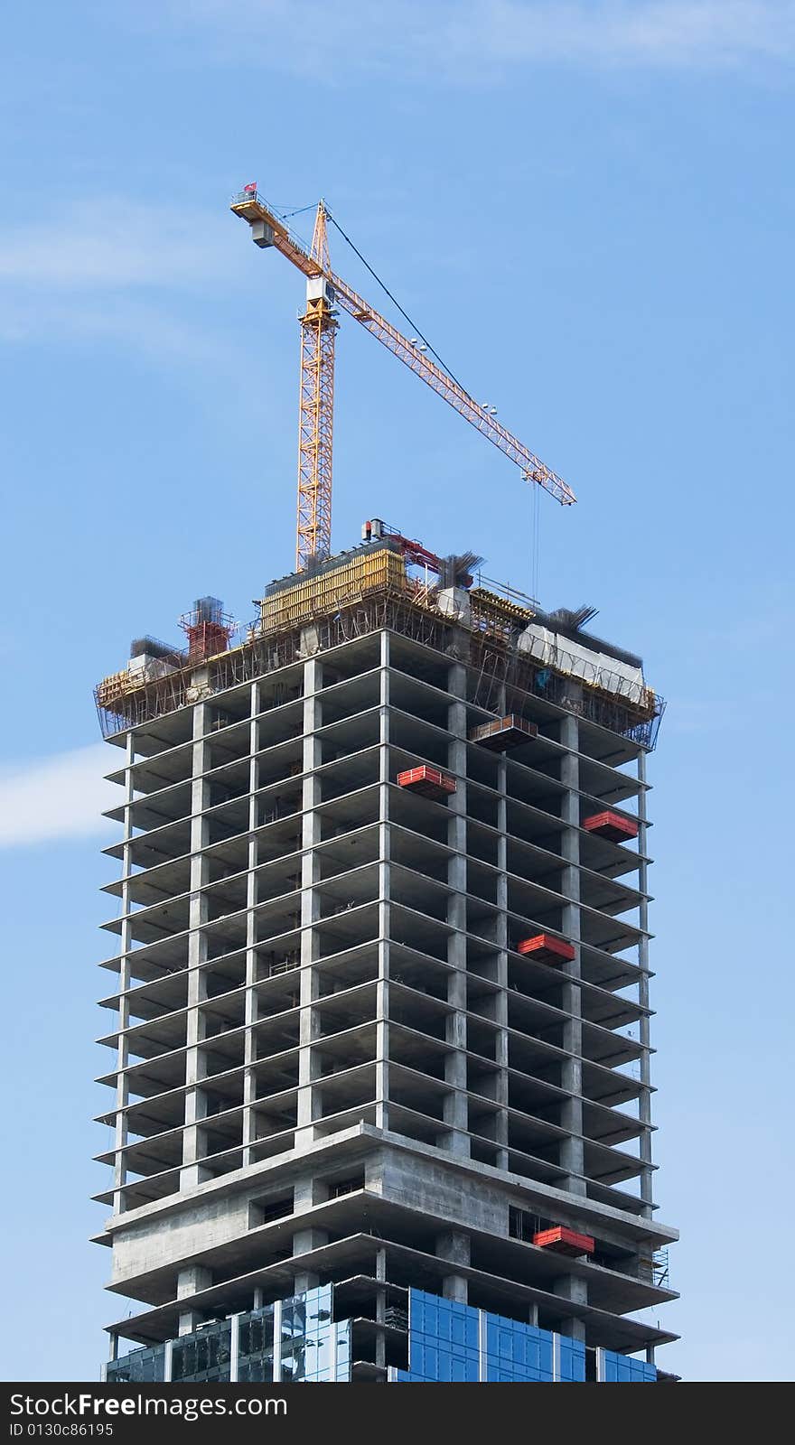 A skyscraper in construction phase with a crane over it. A skyscraper in construction phase with a crane over it