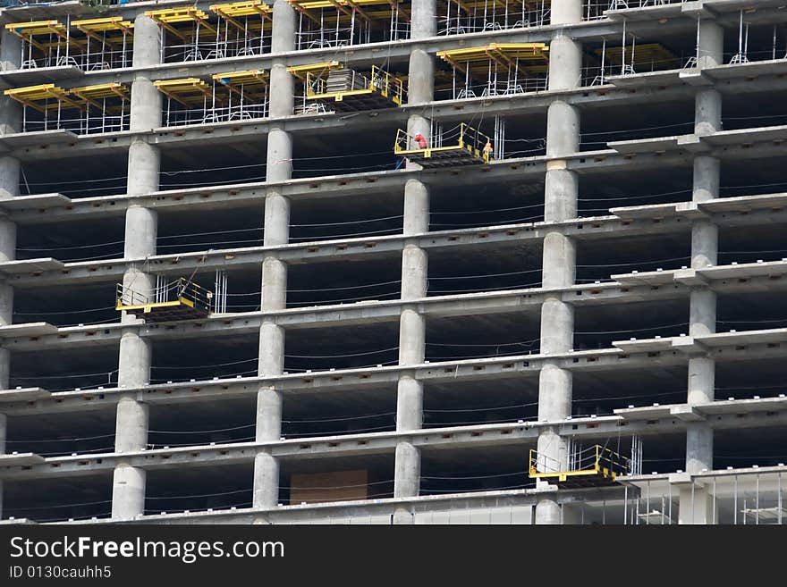 A skyscraper in construction phase with construction equipment on it. A skyscraper in construction phase with construction equipment on it