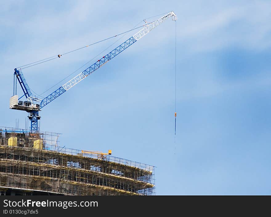 A skyscraper in construction phase with a crane over it. A skyscraper in construction phase with a crane over it