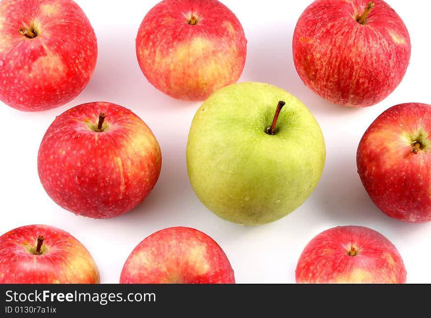 A lot of red and one green apple on a light background. A lot of red and one green apple on a light background