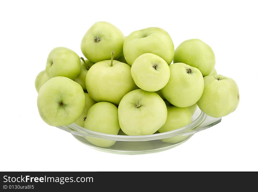 Green apples in a glass plate on a white background. Green apples in a glass plate on a white background