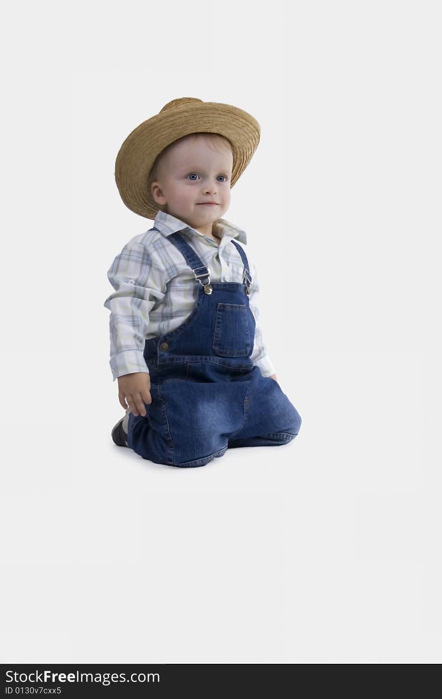 Sitting boy with straw hat on egg white background