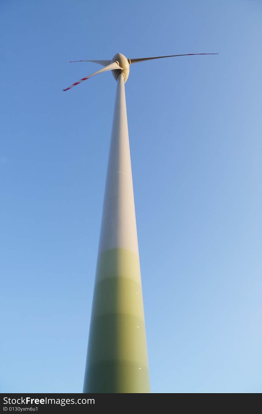 Single wind turbine over blue sky. Alternative energy source. Single wind turbine over blue sky. Alternative energy source.