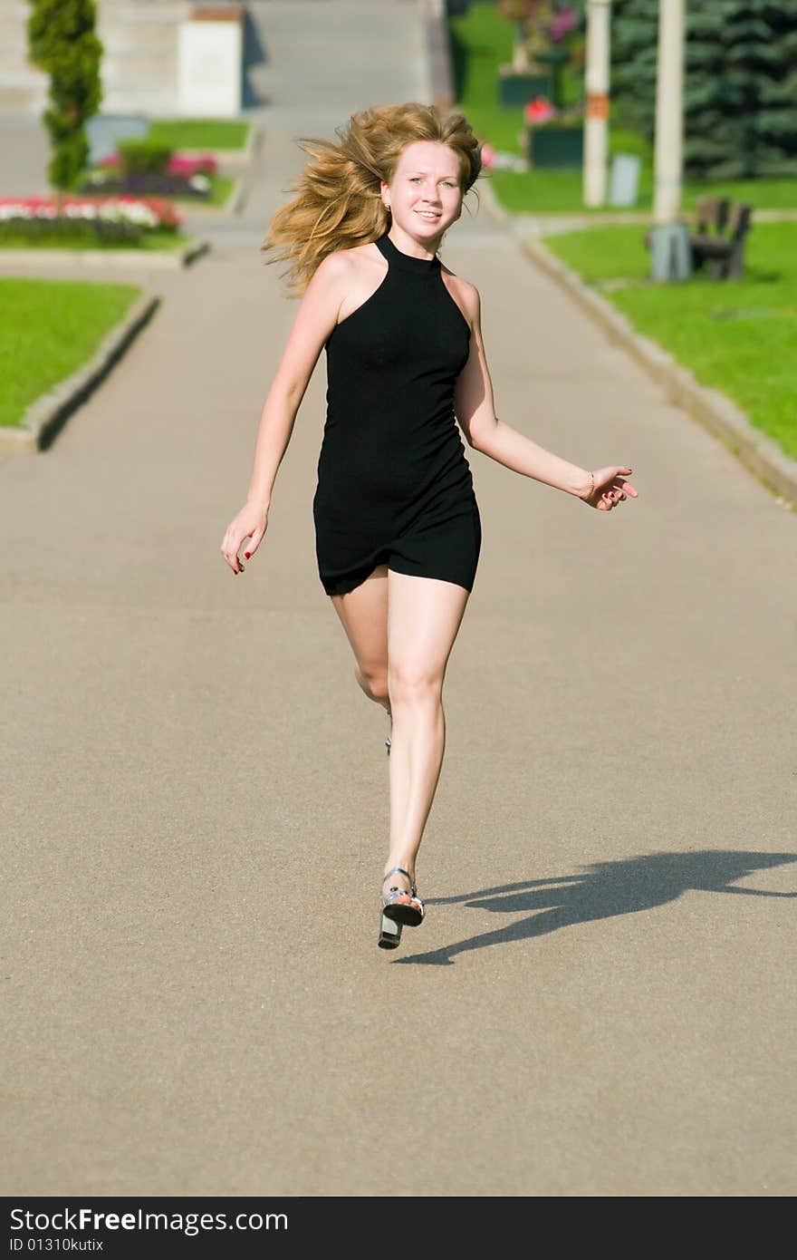 Beautiful girl runs on a path in park. Beautiful girl runs on a path in park