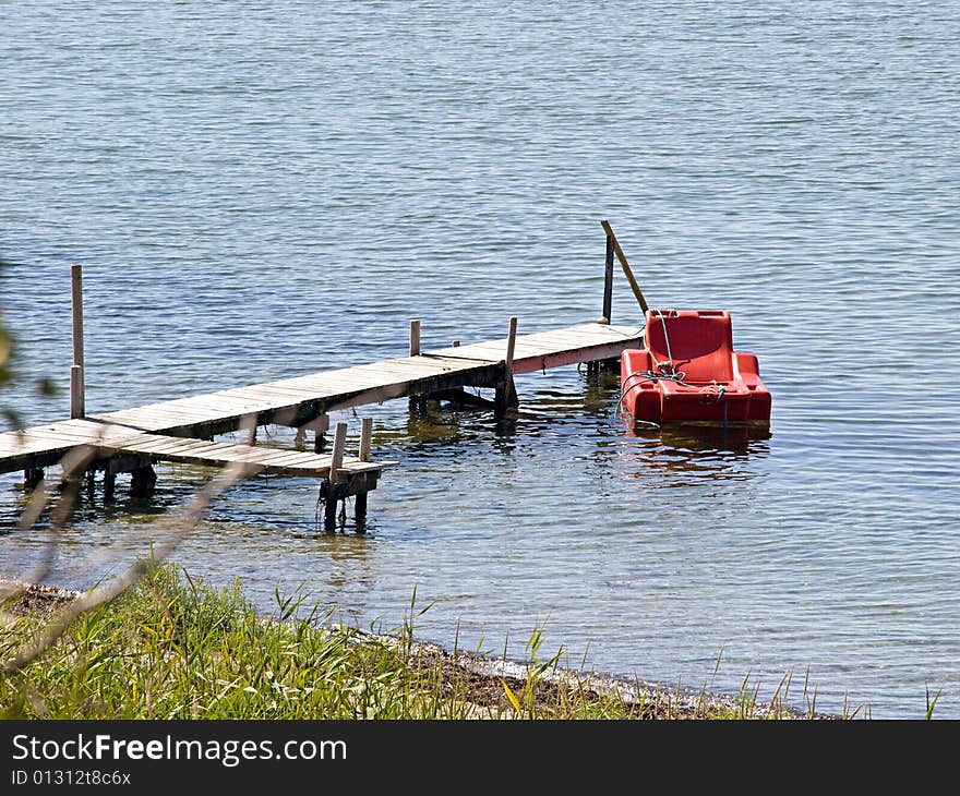 Small wooden pier jetty with armchair