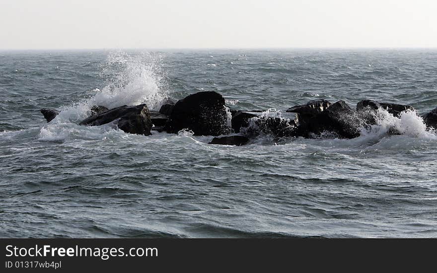 Waves breaking over rocks in the ocean. Waves breaking over rocks in the ocean