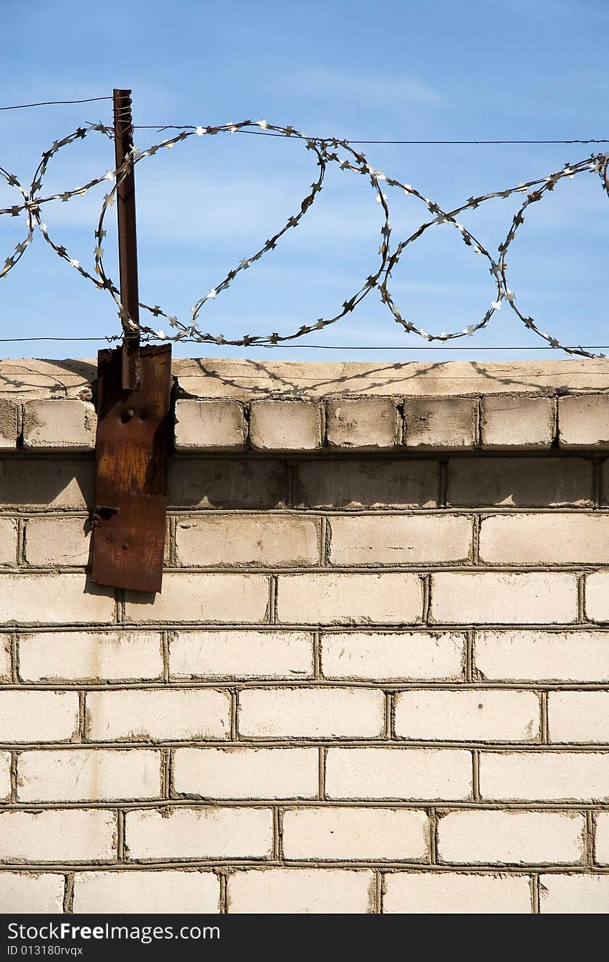 Barbed wire on the background of the blue sky. Symbol of the daydream on the liberty.