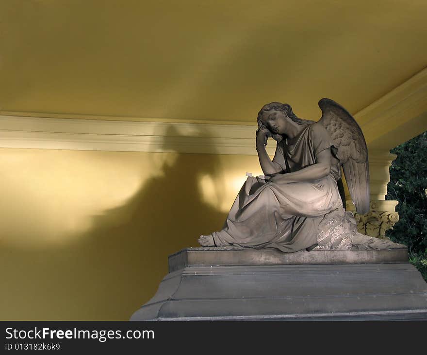 A statue of an angel on top of a tomb. A statue of an angel on top of a tomb