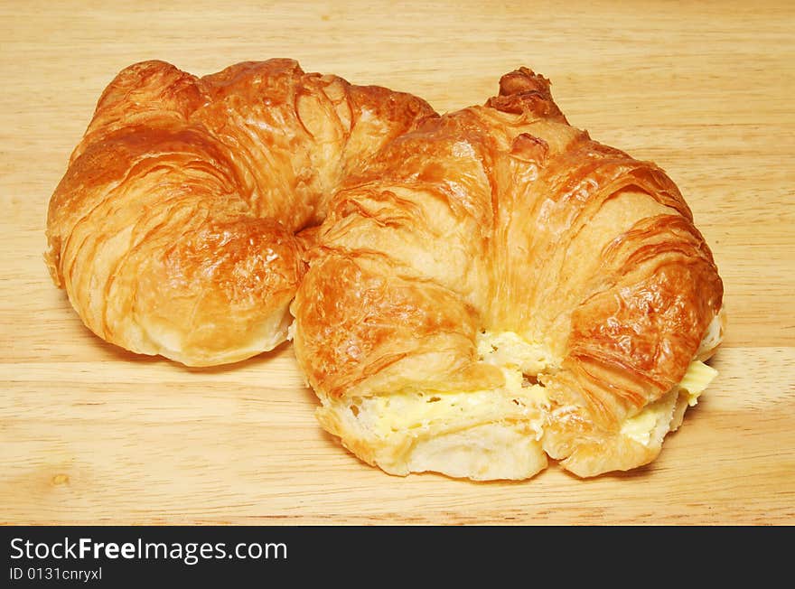 Two croissants on a wooden bread board